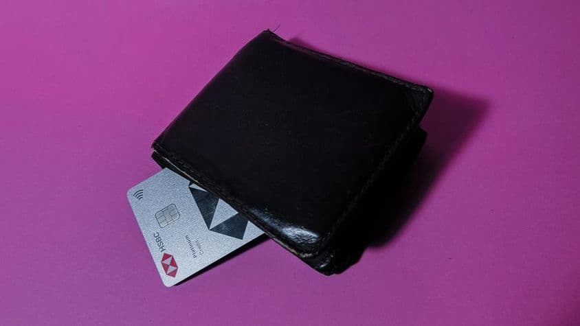एक पुराने काले बटुए में एचएसबीसी क्रेडिट कार्ड।