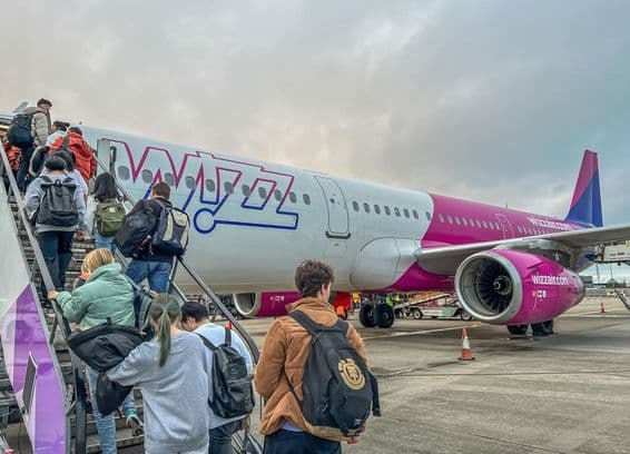 विज़ एयर विमान में सवार होते यात्री।