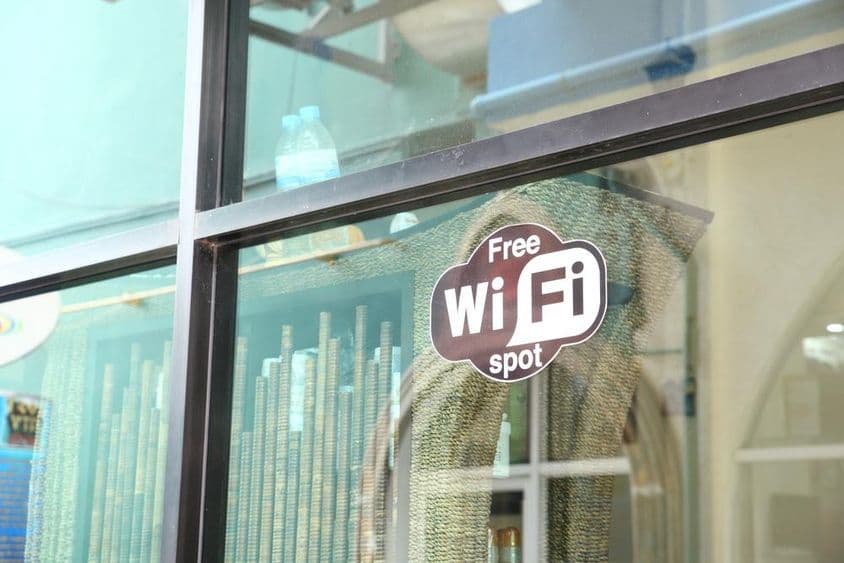 कैफे की खिड़की में मुफ्त वाईफाई का विज्ञापन करने का साइन।