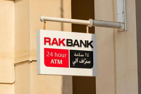 RAKBANK एटीएम साइन लाल और काले आंशिक टेक्स्ट में।