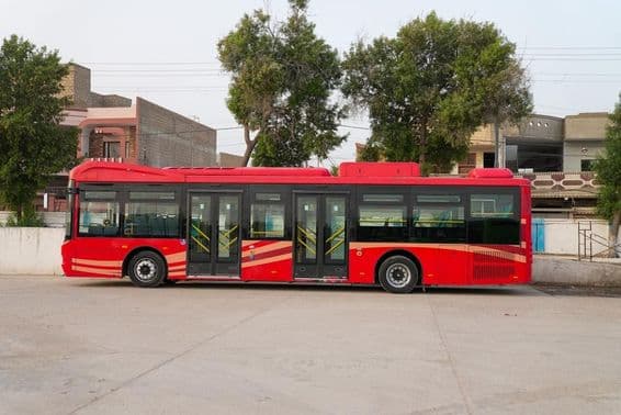 एक लाल दुबई बस खड़ी हुई दिख रही है।