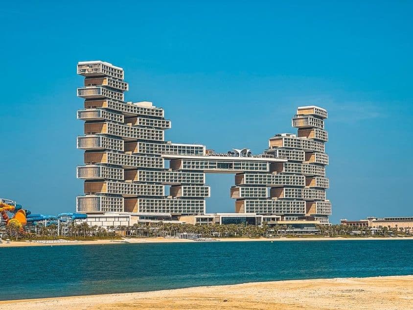 पृष्ठभूमि में अटलांटिस द रॉयल होटल के साथ आग और समुद्र तट।