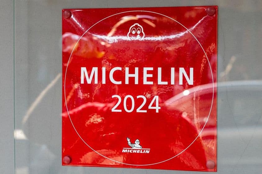 एक रेस्तरां की दीवार पर स्थित मिशलिन गाइड 2024 की प्लेट।