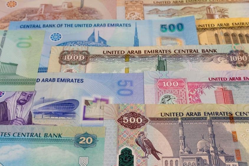 मेज़ पर 20, 50, 100, 500, 1000 मूल्य के दिरहम नोट।