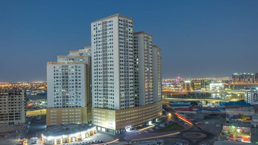 अजमान के शहर का दृश्य छतों और टावरों के साथ।