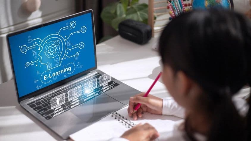 घर पर शैक्षणिक सामग्री पढ़ती छात्रा।