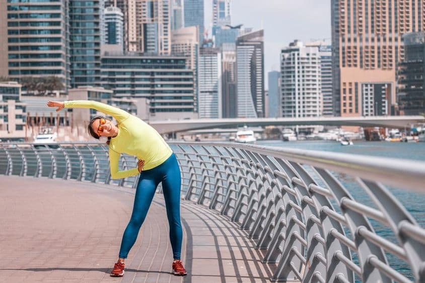 दुबई में मरीना पर दौड़ के बाद एक लड़की खिंचाव करती हुई