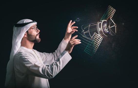 प्रोजेक्टेड सैटेलाइट के सामने मुस्लिम आदमी।