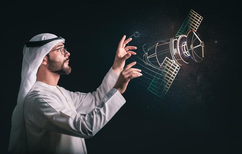 प्रोजेक्टेड सैटेलाइट के सामने मुस्लिम आदमी।