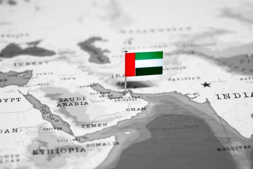 नक्शे पर दुबाई और साथ में यूएई का ध्वज।