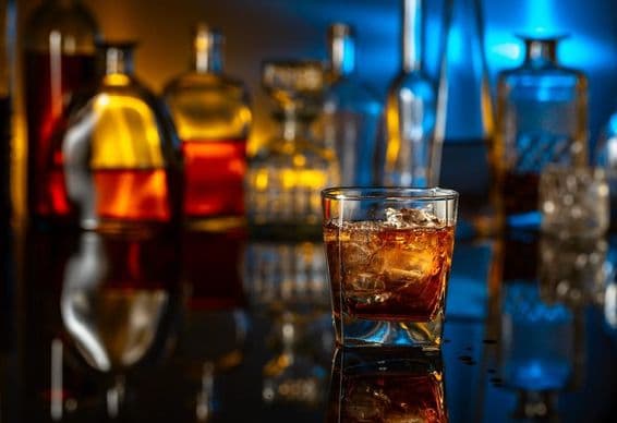 बार में काले टेबल पर बर्फ के साथ व्हिस्की