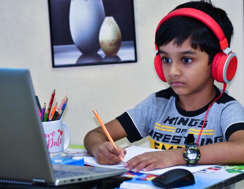 शारजह स्कूल का बच्चा सबक लिखते हुए