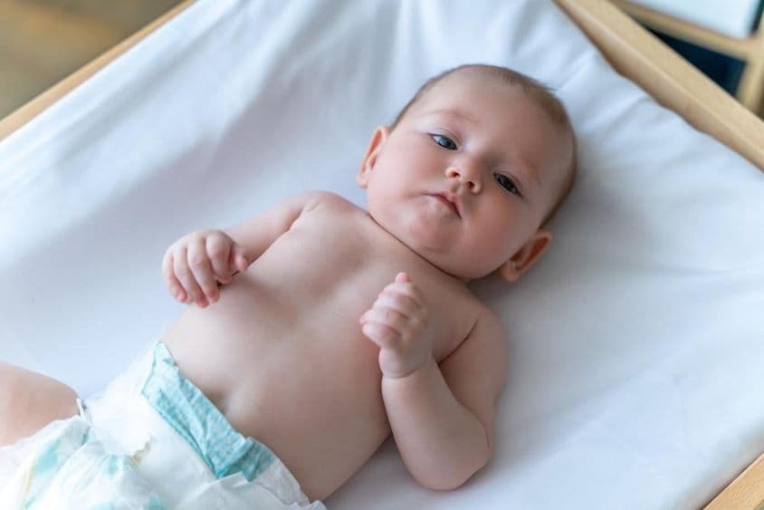 डायपर में सोया हुआ सफेद बच्चा।