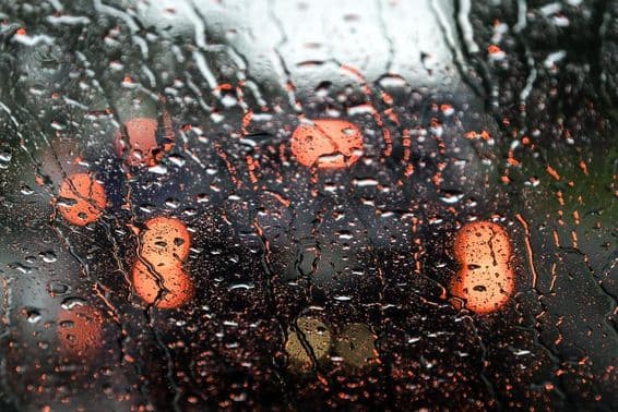 एक गीली कार की खिड़की के माध्यम से दुबई का दृश्य।