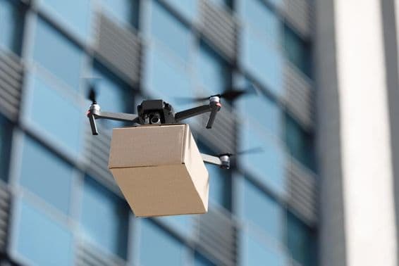 ड्रोन एक पैकेज ले जाता है।