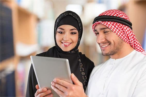 अरबी छात्र टैबलेट पर अध्ययन सामग्री देखते हुए।