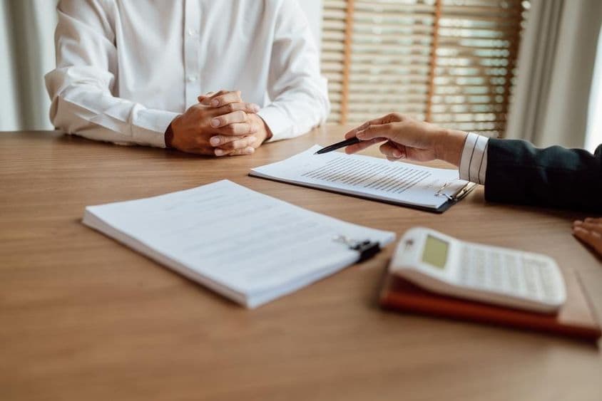 बीमा एजेंट एक अनुबंध पर हस्ताक्षर करते हुए