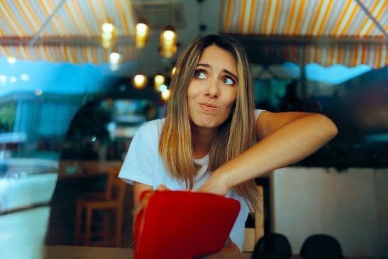 मूल्य वृद्धि के कारण पैसे की कमी के साथ चिंतित महिला मेहमान।