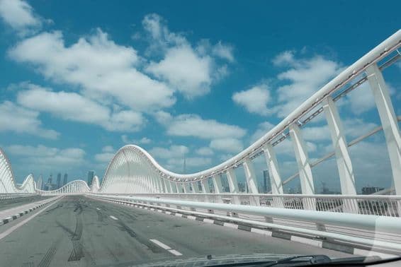 नीले आकाश और बादलों के पृष्ठभूमि के साथ आधुनिक अमूर्त पुल।