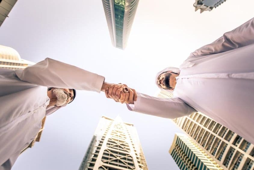 दुबई, संयुक्त अरब अमीरात में बाहर बैठक करते हुए व्यापारी लोग।