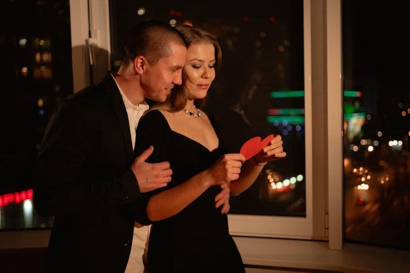 वेलेंटाइन डे पर डेट कर रहा जोड़ा, खिड़की के पास खड़े हुए।