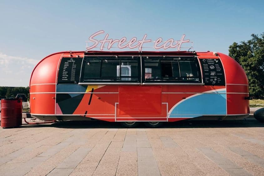 लाल फूड ट्रक, सड़क या चौक के बीच में फास्ट फूड बिक्री।