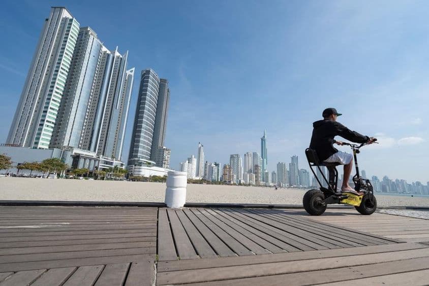 युवा व्यक्ति स्कूटर चलाते हुए।