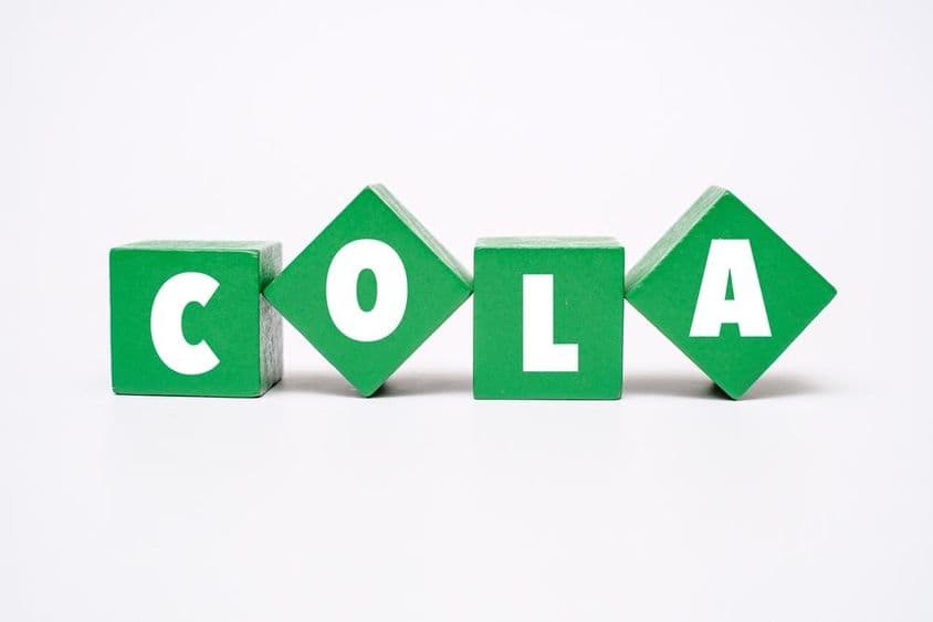एक रंगीन लकड़ी का ब्लॉक जिसमें कोला लिखा हुआ है।