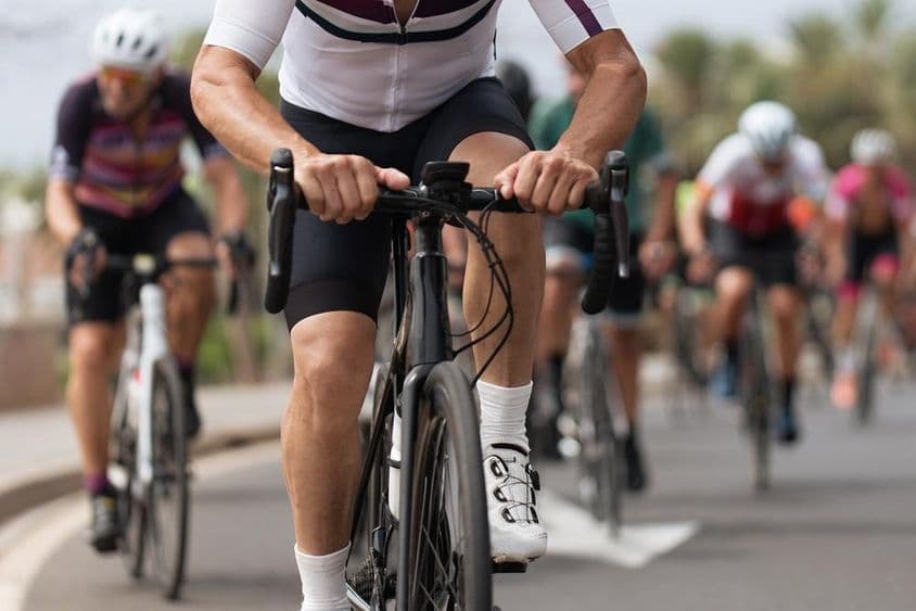 सड़क पर प्रतिस्पर्धा करते हुए साइक्लिस्ट खिलाड़ी।