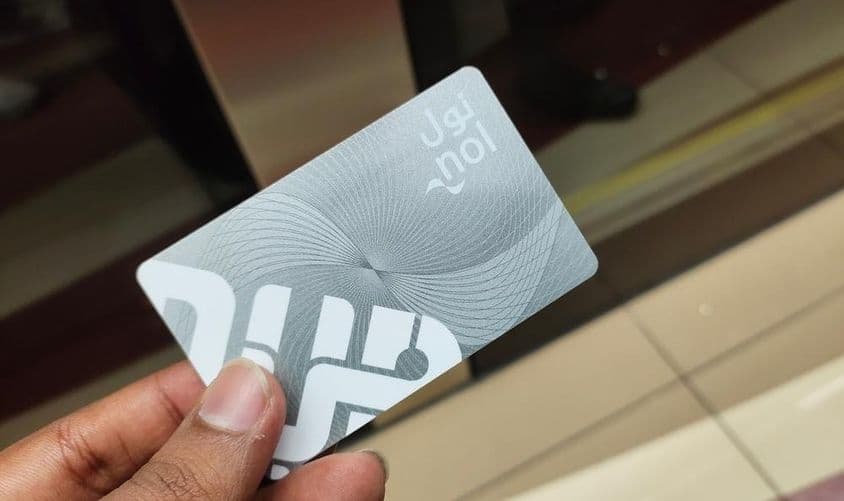 दुबई यात्री मेट्रो ढोल कार्ड प्रवेश पास को पकड़े हुए।