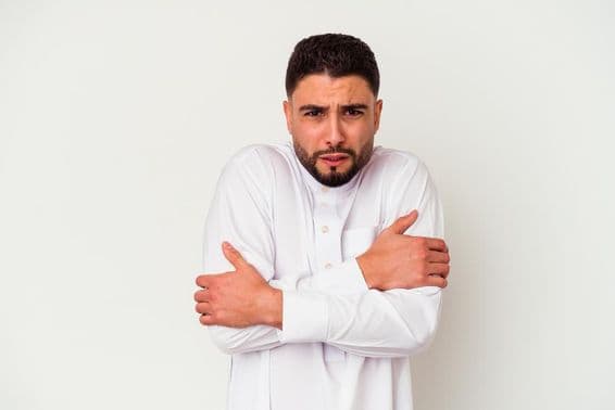 पारंपरिक पोशाक में ठंड से कांपता एक युवा अरब युवक।