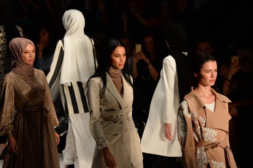 मंच पर विनम्र फैशन वीक में लड़कियाँ।