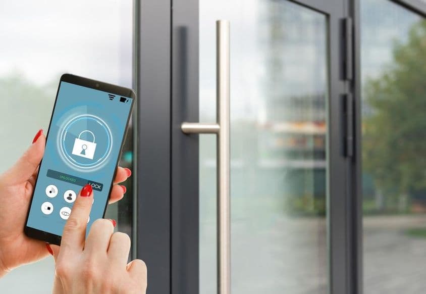 स्क्रीन पर स्मार्ट होम एप्लीकेशन दिखाते हुए स्मार्टफोन।