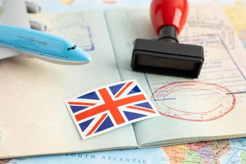 पासपोर्ट स्टाम्प के साथ UK का झंडा।