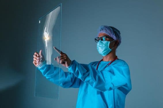 सर्जरी से पहले डॉक्टर के हाथ में रोगी की हड्डियों की एक्स-रे छवि।