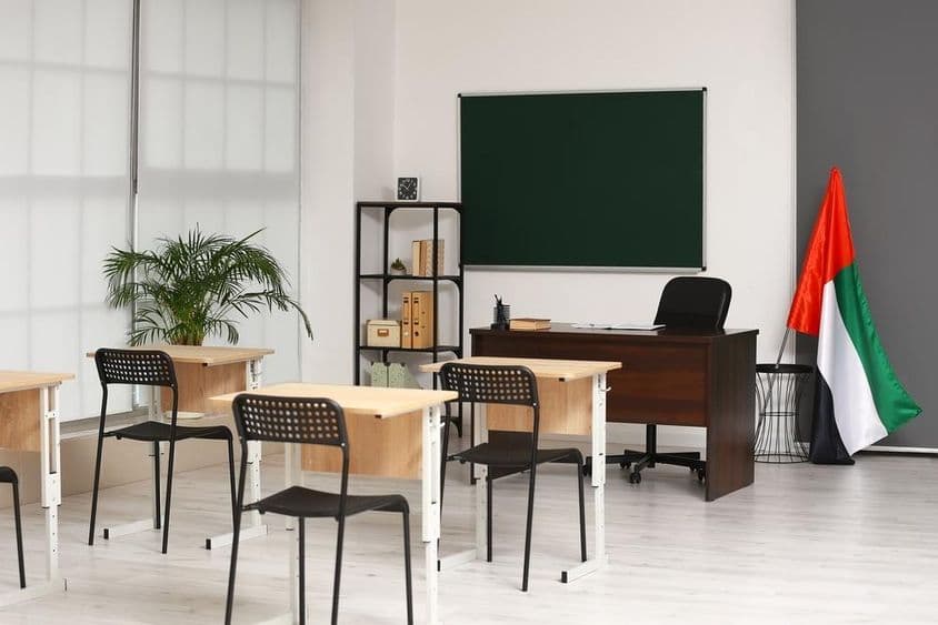 क्लासरूम का आंतरिक दृश्य संयुक्त अरब अमीरात के ध्वज के साथ।