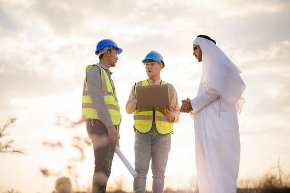 निर्माण के दौरान चर्चा करते एशियाई इंजीनियर और अरबी व्यवसायी