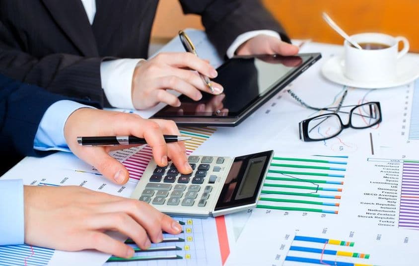 ग्राफ, कैलकुलेटर, टैबलेट, डेटा का अध्ययन करते हुए मेहनती हाथ।