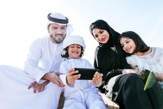 एक छोटा बच्चा फोन पर कार्टून देख रहा है।