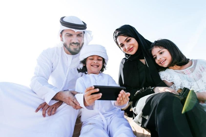 एक छोटा बच्चा फोन पर कार्टून देख रहा है।