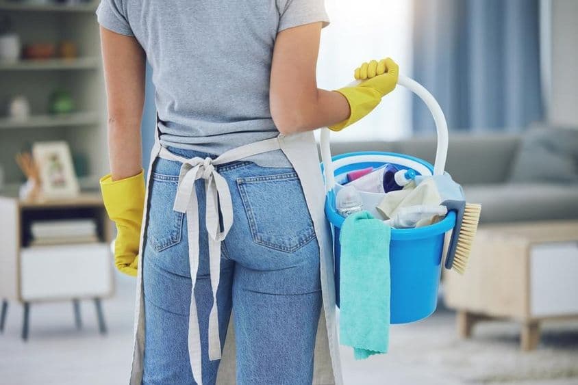 लिविंग रूम में काम कर रहा घरेलू सहायक।