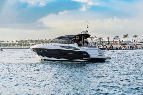 दुबई के बंदरगाह के पास एक लक्जरी यॉट नौकायन कर रही है।