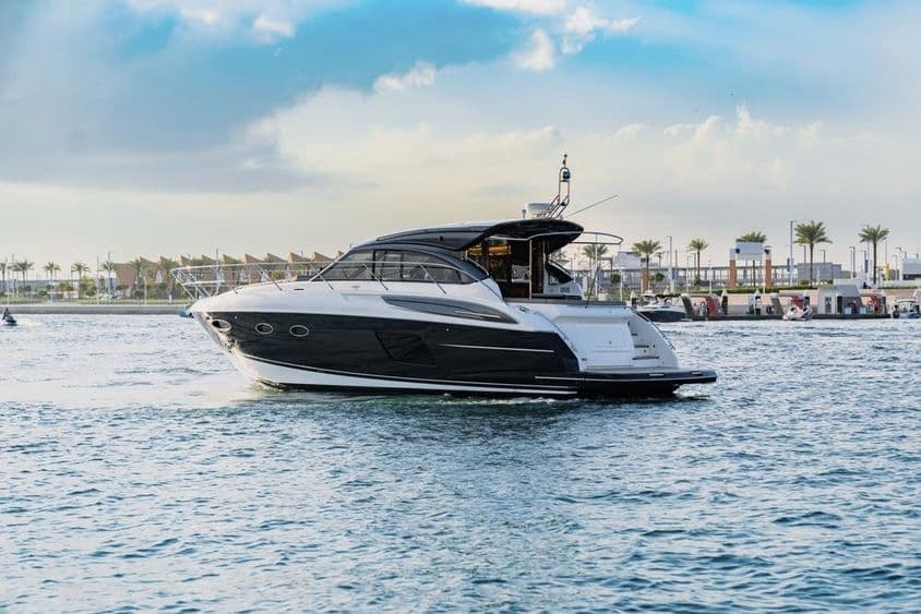 दुबई के बंदरगाह के पास एक लक्जरी यॉट नौकायन कर रही है।