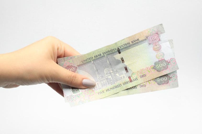 एक महिला के हाथ में ५०० एईडी मुद्रा।