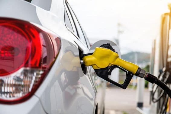 दुबई का एक व्यक्ति गैस स्टेशन पर कार में पेट्रोल पंप कर रहा है।