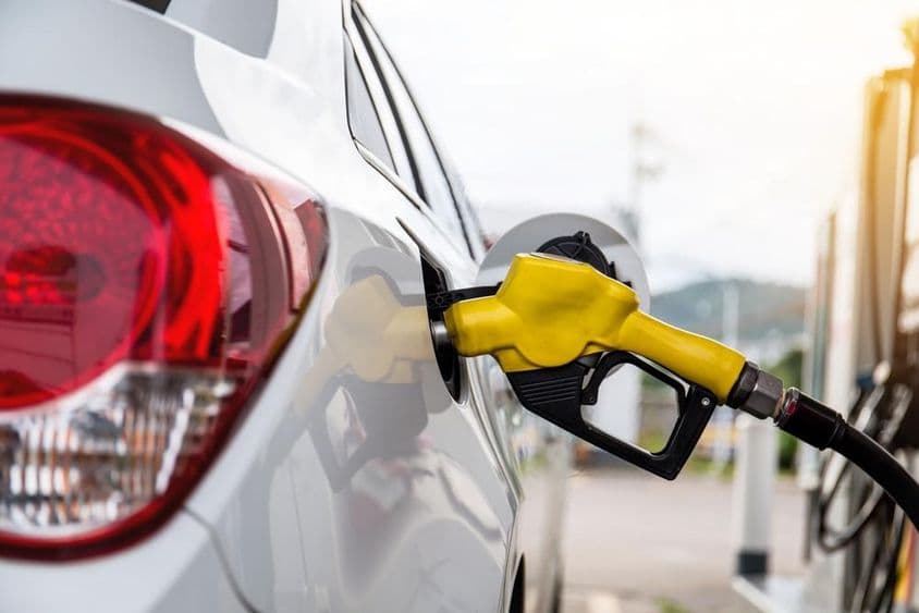 दुबई का एक व्यक्ति गैस स्टेशन पर कार में पेट्रोल पंप कर रहा है।