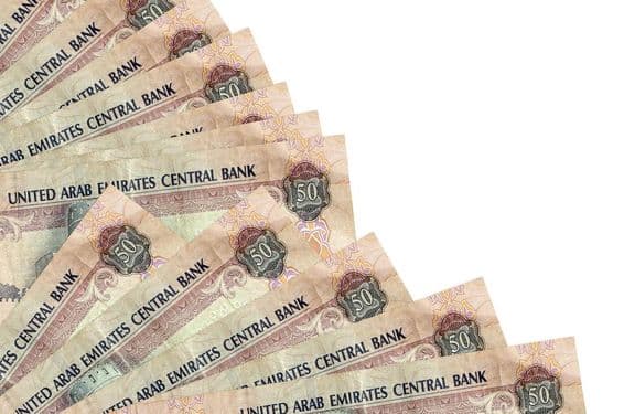 ५० संयुक्त अरब अमीरात दिरहम का बैंकनोट एक मेज पर पड़ा हुआ है।