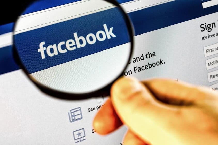 आवर्धक कांच के माध्यम से एक मॉनिटर पर Facebook मुख्य पृष्ठ का स्क्रीनशॉट।