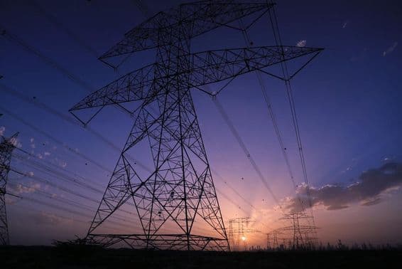 दुबई के दृश्य के साथ सूर्यास्त के दौरान हाई वोल्टेज टावर।