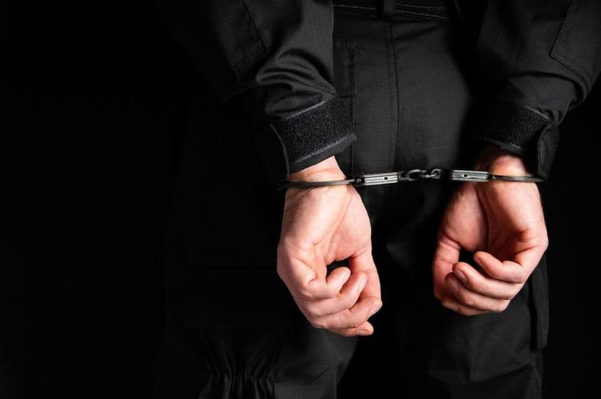 हथकड़ी में एक अपराधी के हाथ।
